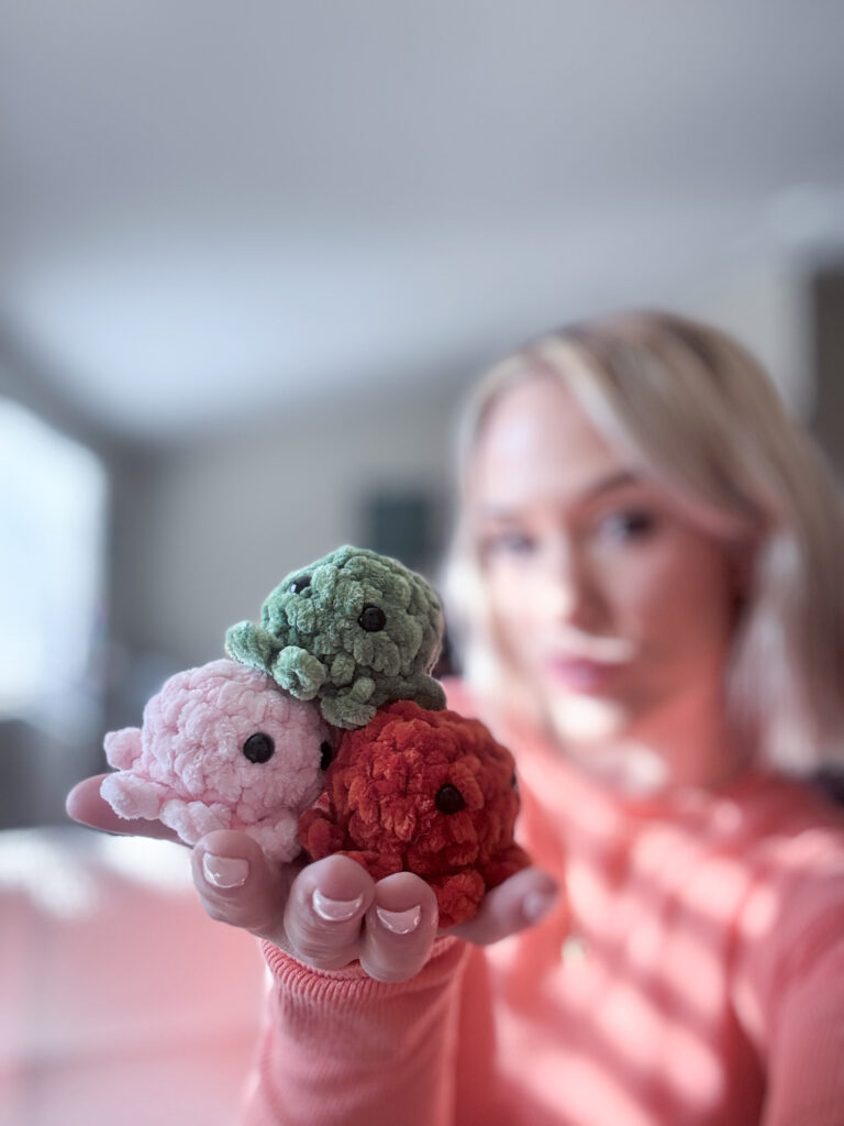 Stuffed crochet octopus plushie sitting on woman's hand